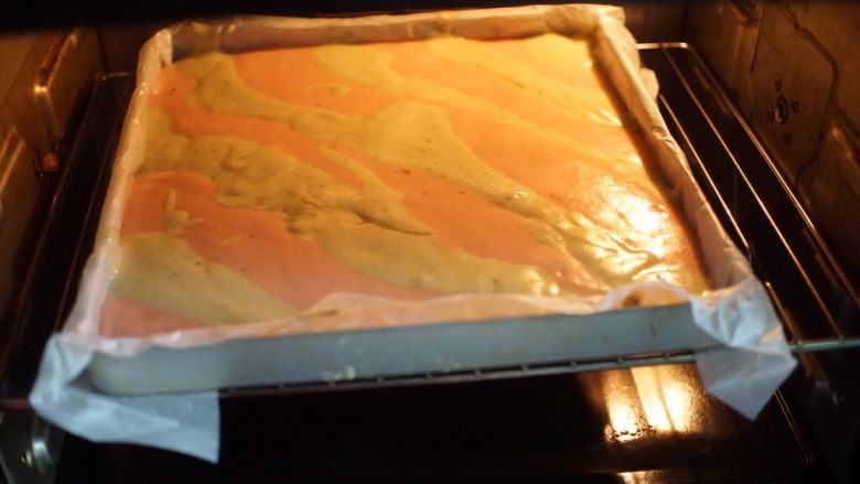 圣诞蛋糕卷,烤盘铺上油纸，将两种面糊分别间隔倒入烤盘中，放入预热好的烤箱中层以上下火150摄氏度烤20分钟