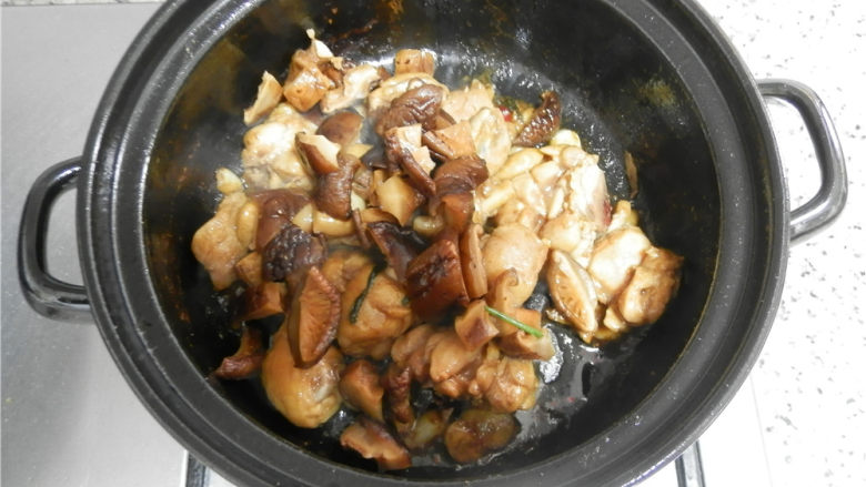 砂锅香辣鸡煲,加入香菇翻炒。