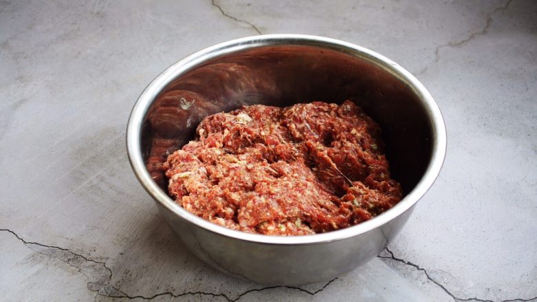 胡萝卜牛肉馅饺子,先用香油油把葱花和洋葱碎拌一下的目的是防止葱汁外溢，造成肉馅葱味过重。
