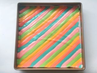 彩虹蛋糕
,烤盘底铺油纸，将5种彩色分别挤上均匀的彩条

