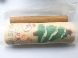 圣诞树蛋糕卷,之后借用擀面杖的力度，将蛋糕卷卷起来，卷好后，用擀面杖压一下油纸轻轻收紧，定下形

