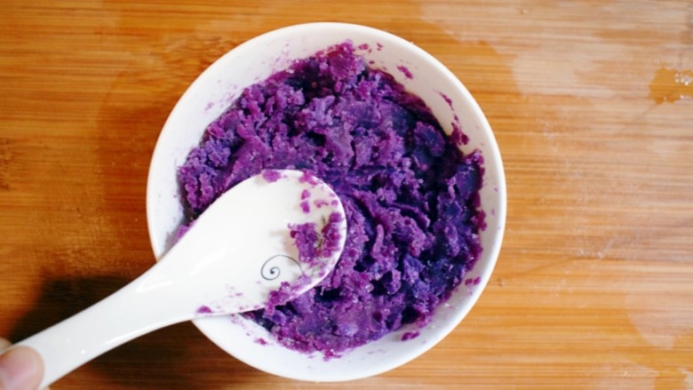 紫薯山药糯米饼（微笑饼）,用勺子将紫薯捣碎，使得白糖与紫薯充分混合，紫薯泥就做好了。