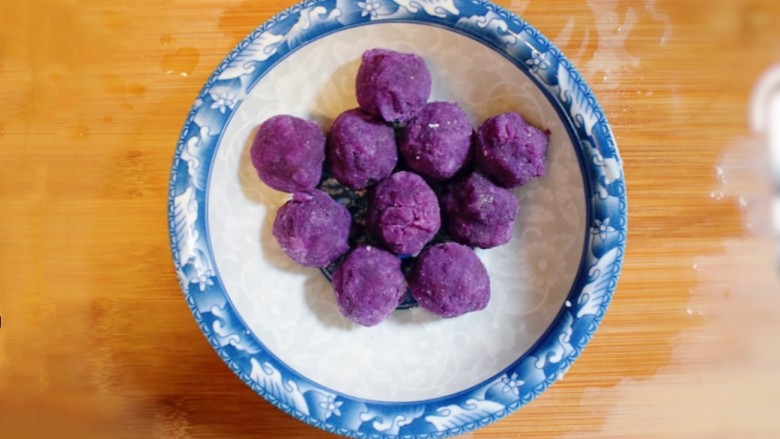 紫薯山药糯米饼（微笑饼）,将紫薯泥揉成大小均匀统一的小团子，备用。