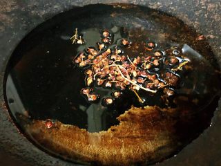 香葱爆海螺片,锅中放入底油加热再放入花椒炸香后把花椒捞出