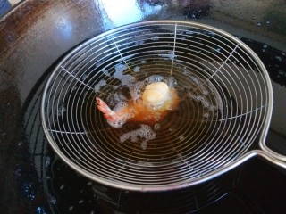新文美食  凤还巢,在把小球蘸着糊料沾在虾身体上，放入漏勺炸制固定即可。