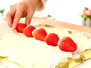 圣诞草莓蛋糕卷,趁蛋糕胚子热时，抹上土豆泥，中间放一排草莓
