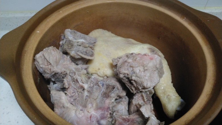 排骨鸡腿炖平菇,捞出姜、葱、排骨、鸡腿到砂锅中。