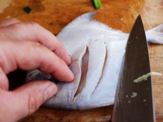 酱焖海鲳鱼,把沥干水分的鲳鱼用刀改刀，这样在焖鱼的时候可以入味很快。