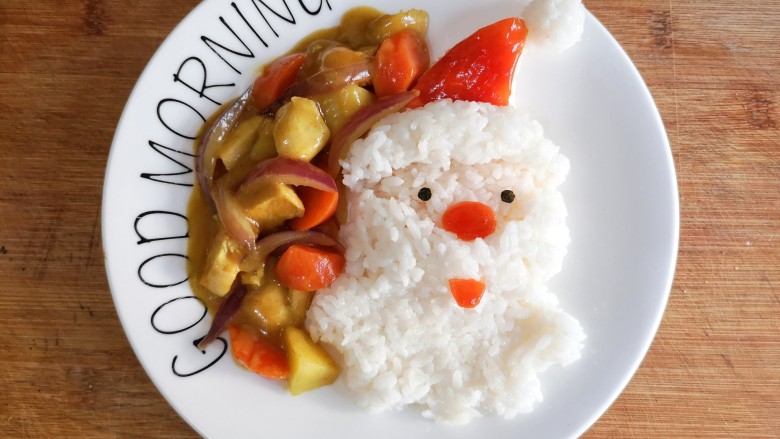 圣诞咖喱鸡饭,将煮好的咖喱鸡浇在米饭旁边，在帽子，鼻子和嘴上在涂一层番茄酱增色。
