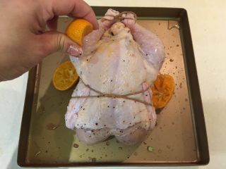 砂糖橘风味烤鸡,然后鸡胸朝上，将剩余的砂糖橘挤汁淋在鸡身上