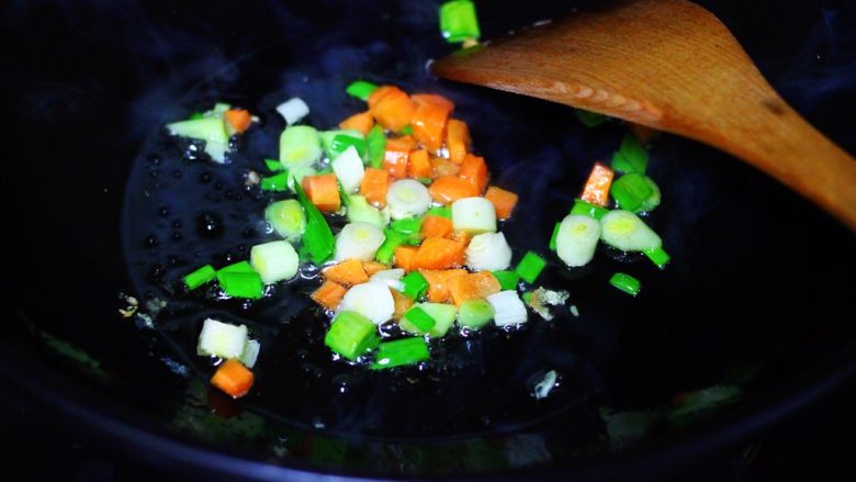 海虹蒜苗什锦蛋炒饭,另起锅倒入剩下的30克花生油烧热后，先爆香蒜苗和胡萝卜丁。