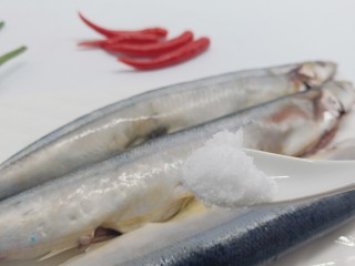 简单美味的麻辣烤秋刀鱼,加盐一勺，均匀地涂抹在鱼身上。