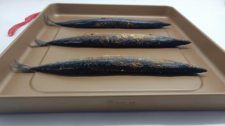 简单美味的麻辣烤秋刀鱼,腌制好的秋刀鱼码在烤盘上。