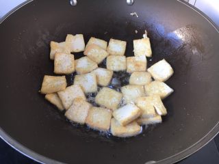 豌豆鲜鸡汁烧豆腐,热锅凉油（2勺），放入豆腐，将豆腐的两面都煎成浅浅的金黄色。