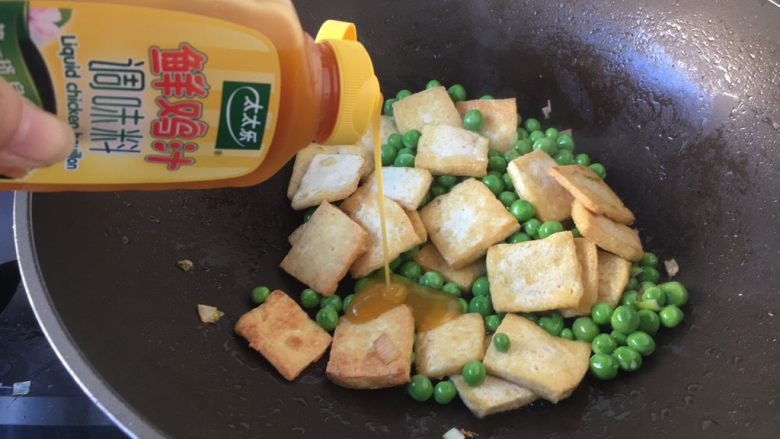 豌豆鲜鸡汁烧豆腐,放入3～4滴的鲜鸡汁，翻炒均匀。