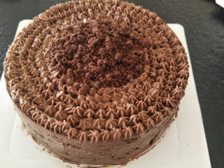 最经典浓郁巧克力奶酪蛋糕,最后，可以在上面用多余的奶油挤上花纹。放上装饰。