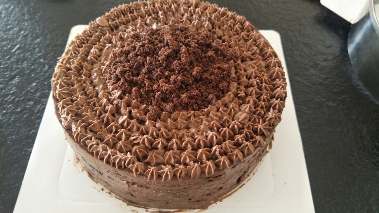 最经典浓郁巧克力奶酪蛋糕,最后，可以在上面用多余的奶油挤上花纹。放上装饰。