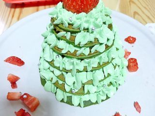 圣诞树松饼,放一颗草莓在奶油树顶，草莓粒装饰一下碟边，加上银色糖珠装饰
