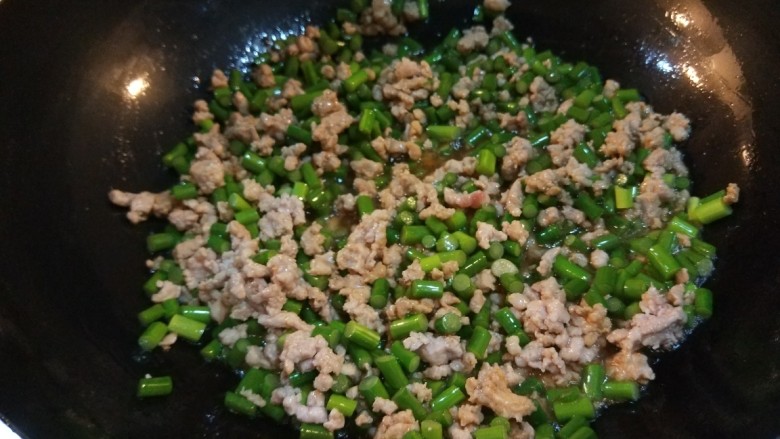 新文美食  肉末炒蒜苔,倒入肉末炒散，在倒入蒜苔丁炒均匀。
