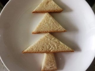营养早餐1209之圣诞树,找个盘子，先放菱形的树干，最大的三角形放下面，依次摆好在盘子中，圣诞树的形状就出来了，也是今天早餐中的主食部分。