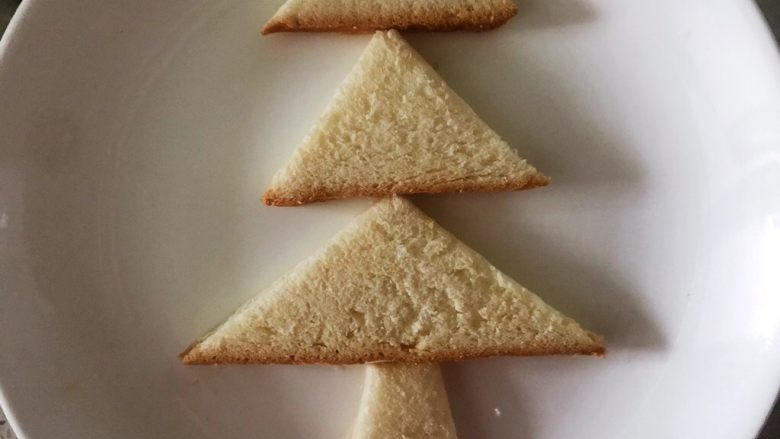 营养早餐1209之圣诞树,找个盘子，先放菱形的树干，最大的三角形放下面，依次摆好在盘子中，圣诞树的形状就出来了，也是今天早餐中的主食部分。