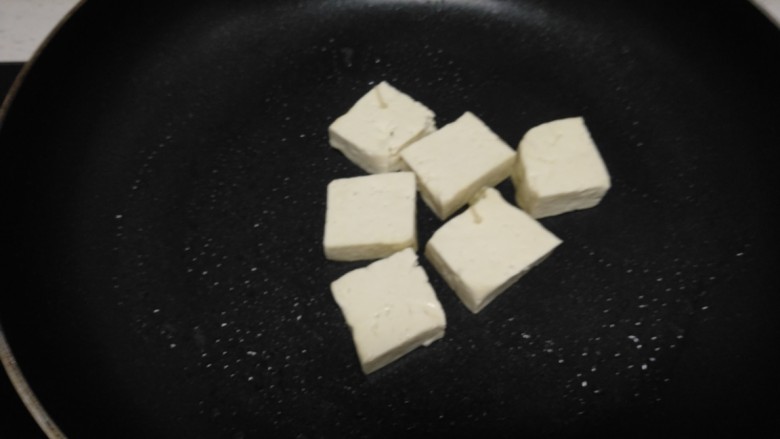 豆腐炒平菇、金针菇,不粘锅中放入适量油，放入豆腐块。