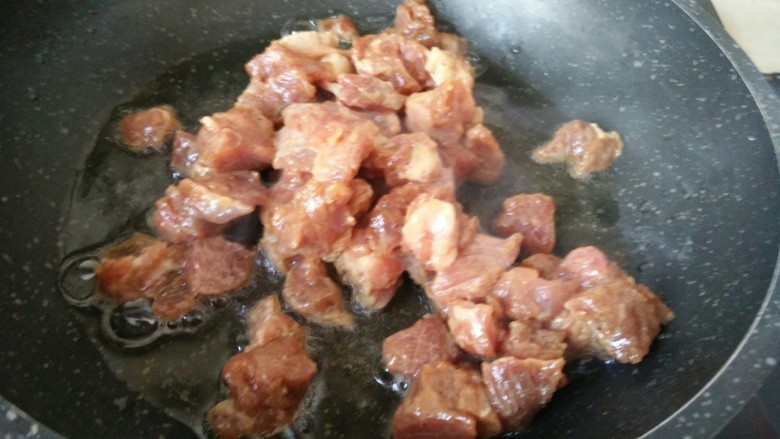 豌豆牛肉粒,另起锅加油烧热放入腌好的牛肉丁翻炒