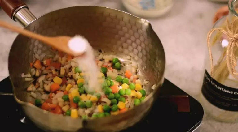 巧用普通的电饭锅,分分钟能做出好吃的煲仔饭,快收起来试试!,再加入青豆、玉米粒和适量的盐调味后翻炒均匀