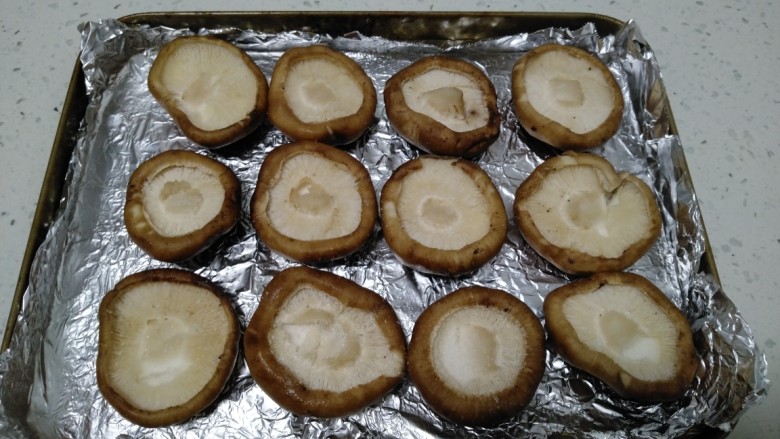 烤香菇,烤盘上垫上锡纸，摆上香菇，在香菇上均匀撒上少许盐。