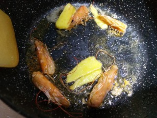 超级鲜美的海鲜粥,锅里放少量油，下生姜片和虾头去炒