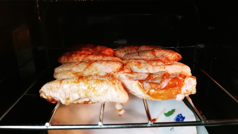 意式红烩中翅,鸡中翅摆放在烤架上，放入微波炉