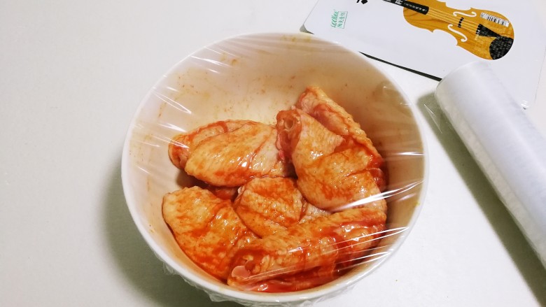意式红烩中翅,用保鲜膜封住碗口，放入冰箱冷藏腌制二十四小时，中途翻个面