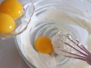 轻乳酪蛋糕（芝士蛋糕），醇香美味,一个一个加入蛋黄，每次加完之后都要搅打顺滑。