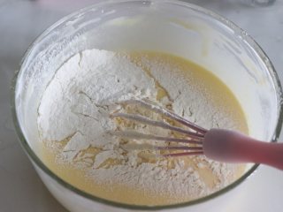 轻乳酪蛋糕（芝士蛋糕），醇香美味,筛入低筋面粉，画Z字拌到无干粉状态。不能一直搅拌，面粉起筋。