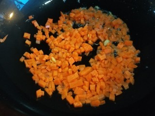 新文美食  蔬菜火腿蛋炒饭,在倒入胡萝卜丁炒均匀。