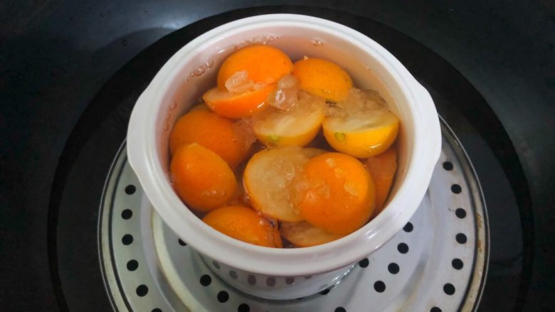 荸荠金桔糖水,锅里放入适量水烧开，放入蒸架，把罐子放到蒸架上，在罐子里倒入开水。