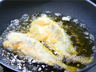 酥炸黄花鱼,炸至黄花鱼自动浮起来，证明鱼肉基本熟透，这时可以用锅铲把鱼翻一下面，再调成大火炸5分钟左右，将鱼身上的水汽和油脂逼出来。