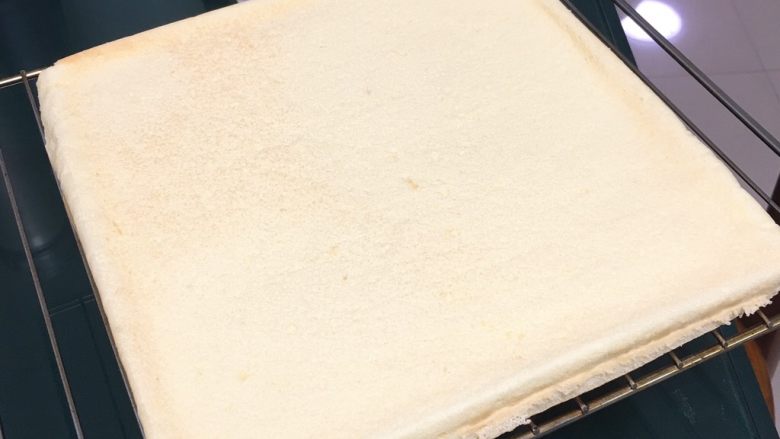 桑椹蛋糕卷,冷却一下，有余温的时候另一张烤盘纸覆盖上去，翻个身。