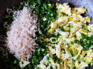 百吃不厌的韭菜盒子,炒好鸡蛋后，稍微放凉后加入淡干虾皮，再放入适量的盐、花椒粉和鸡精调味后，加入用刀切碎的韭菜。