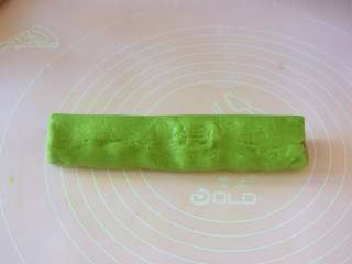 西瓜小饼干,轻轻的从一面卷起来，如果怕抹茶面片会断裂，可以借助刮板慢慢卷，然后包一层保鲜膜，放冰箱冷冻1个小时