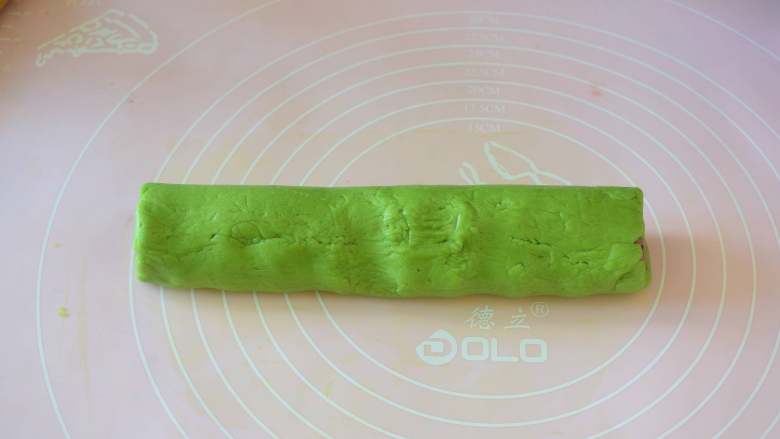 西瓜小饼干,轻轻的从一面卷起来，如果怕抹茶面片会断裂，可以借助刮板慢慢卷，然后包一层保鲜膜，放冰箱冷冻1个小时