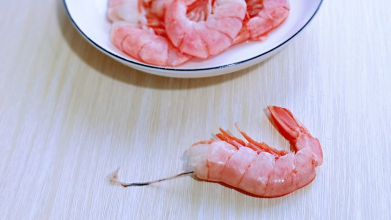 红虾尾这样做味道太赞了,首先将红虾尾去除虾先，从虾头的部位用力一拉，虾线就出来啦！依次做完。