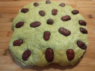 新文美食  菠菜红枣发糕,蒸好的发糕放在案板上切成块。