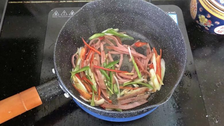 5分钟搞定的橄榄菜火腿丝炒面,6、倒入火腿丝和青红椒丝翻炒均匀。