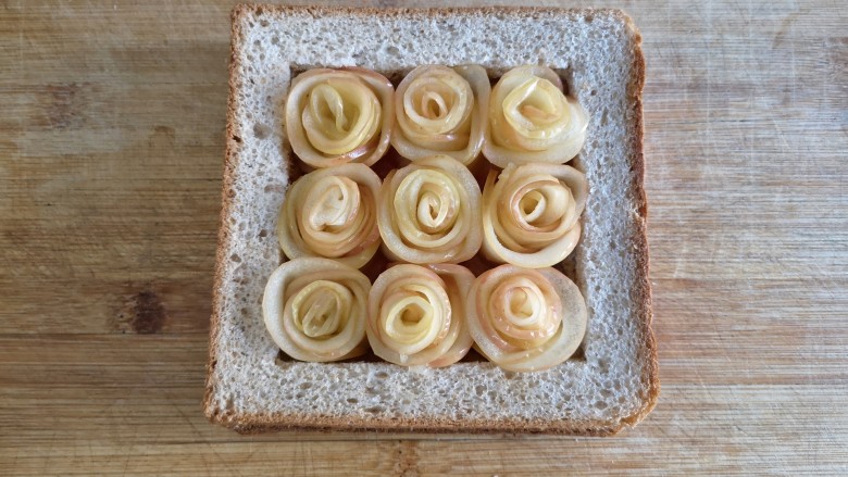 苹果玫瑰花土司,直到做完九朵苹果玫瑰花，全部置于土司框中。