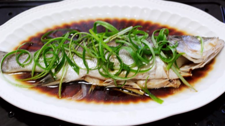 鲜美无比的粤式清蒸鲈鱼,把蒸鱼豉油倒均匀后。