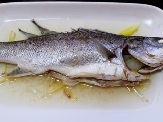 鲜美无比的粤式清蒸鲈鱼,把蒸好的清蒸鱼从蒸烤箱取出来。