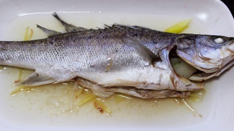 鲜美无比的粤式清蒸鲈鱼,把蒸好的清蒸鱼从蒸烤箱取出来。