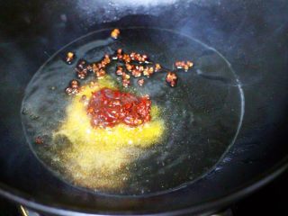 健脾消食的蒜苗爆鸡胗,热锅加入花生油烧至六成热时小火慢慢炒香花椒后，倒入郫县豆瓣酱。