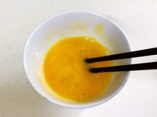 馒头蔬菜什锦沙拉,用筷子把鸡蛋打散开来。